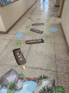Sensory path with colorful frog and hop sign on school hallway floor.