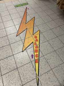 Colorful lightning bolt-shaped sensory path on tiled floor with 'Balance' and 'Finish' markers.
